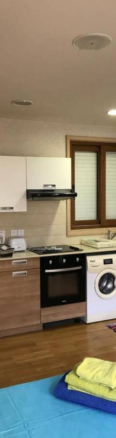 a kitchen with a white refrigerator and a stove at Ithaki Phinikoudes Apartment No. 207 in Larnaka