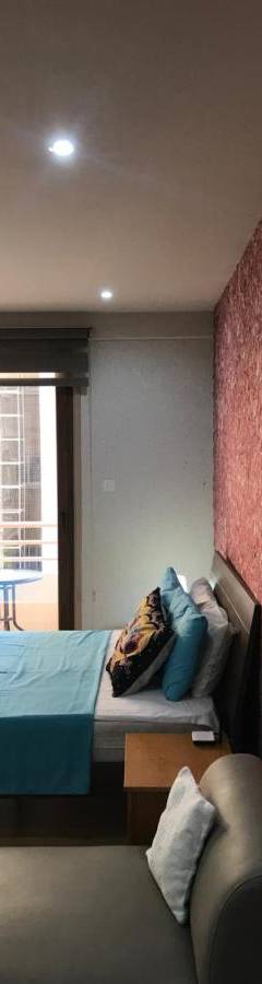 a bedroom with a blue bed and a red wall at Ithaki Phinikoudes Apartment No. 207 in Larnaka