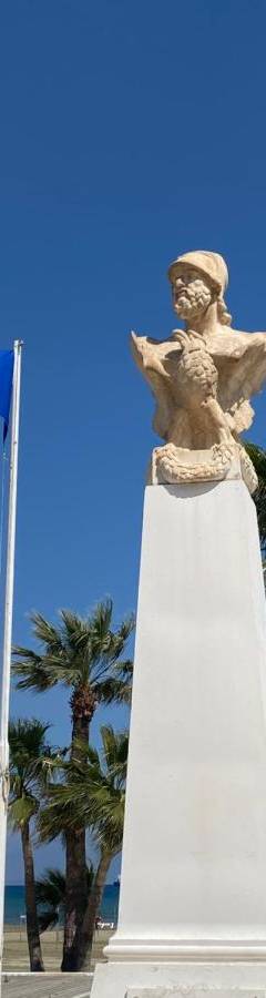 a statue on the beach next to some flags at Ithaki Phinikoudes Apartment No. 207 in Larnaka