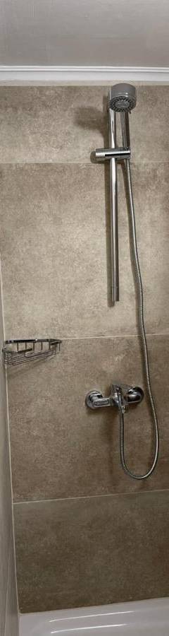 a shower with a shower head in a bathroom at Alex Beach Apartment 33 in Larnaka