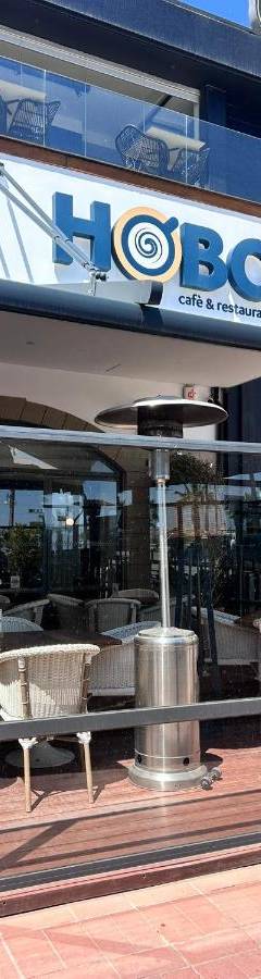 a store front of a restaurant with chairs and tables at Alex Beach Apartment 33 in Larnaka
