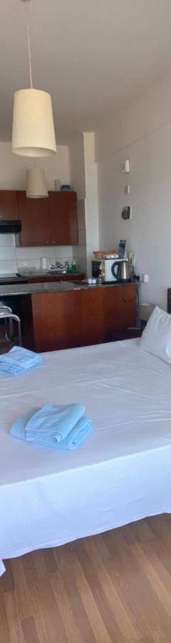 a bedroom with a white bed and a television at Alex Beach Apartment 33 in Larnaka