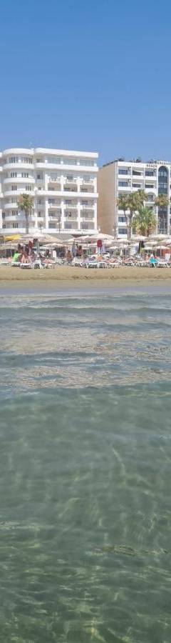 a view of a beach with buildings in the background at Alex Beach Apartment 33 in Larnaka