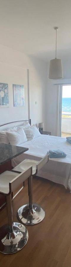 a living room with a bed and a table and a microwave at Alex Beach Apartment 33 in Larnaka