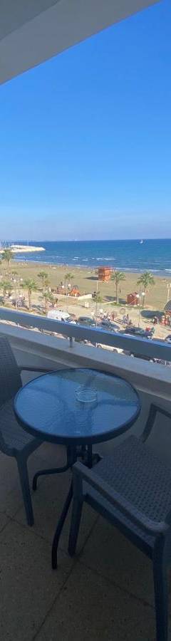 a table and chairs on a balcony with a view of the beach at Alex Beach Apartment 33 in Larnaka