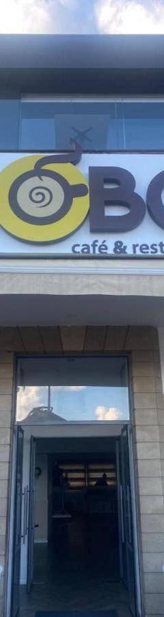 a building with a sign for a cafe and restaurant at Alex Beach Apartment 33 in Larnaka