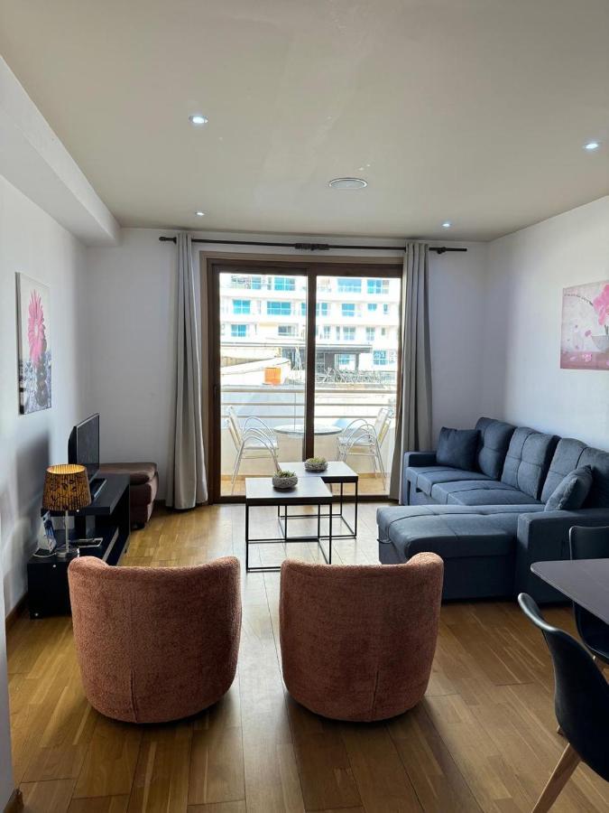 a living room with a blue couch and chairs at Ithaki Phinikoudes Apartments No. 106 in Larnaka