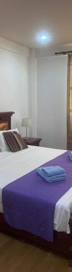 a bedroom with a large bed with two towels on it at Ithaki Phinikoudes Apartments No. 106 in Larnaka