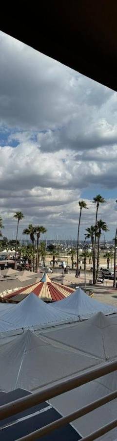 a view of a beach with palm trees and umbrellas at Ithaki Phinikoudes Apartments No. 106 in Larnaka