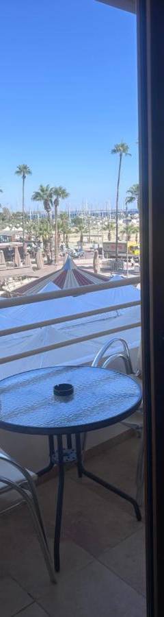 a table on a balcony with a view of the beach at Ithaki Phinikoudes Apartments No. 106 in Larnaka