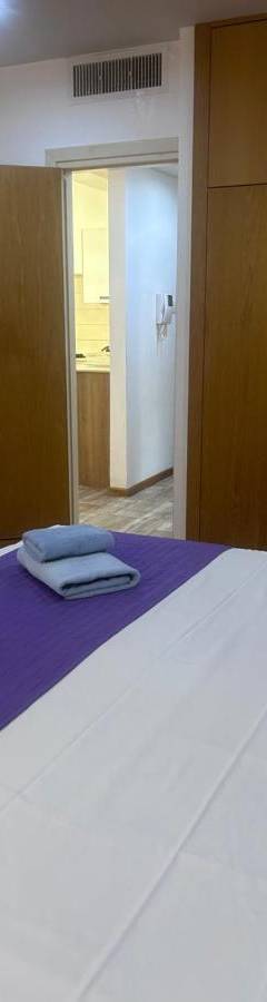 a bedroom with a large bed with two towels on it at Ithaki Phinikoudes Apartments No. 106 in Larnaka