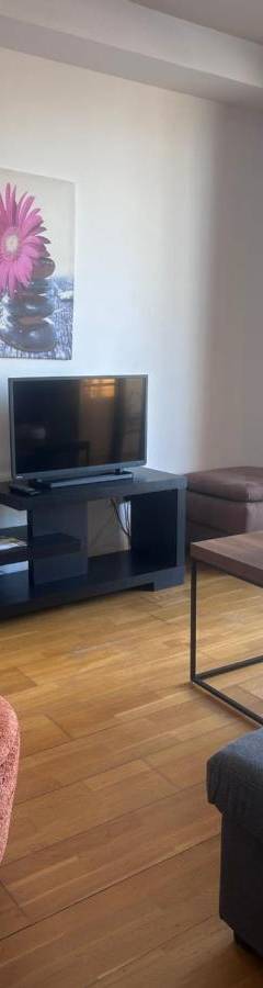 a living room with a tv and a couch and a table at Ithaki Phinikoudes Apartments No. 106 in Larnaka