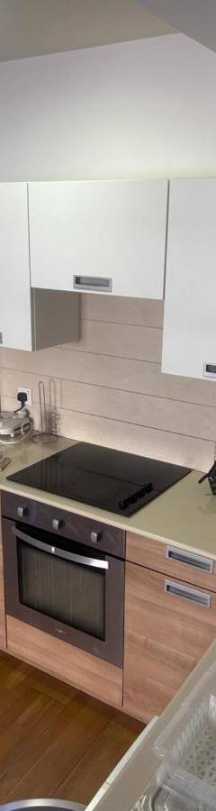 a kitchen with white cabinets and a sink and a refrigerator at Ithaki Phinikoudes Apartments No. 106 in Larnaka