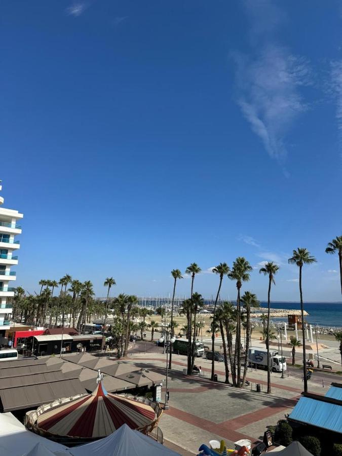 a view of a beach with palm trees and the ocean at Ithaki Phinikoudes Apartment No. 205 in Larnaka
