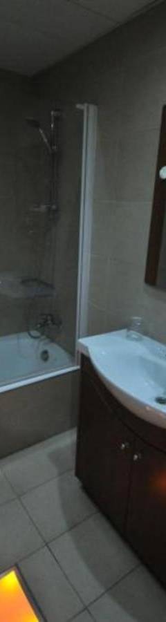 a bathroom with a sink and a shower and a tub at Ithaki Phinikoudes Apartment No. 205 in Larnaka