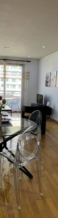 a living room with a glass table and chairs at Ithaki Phinikoudes Apartment No. 205 in Larnaka