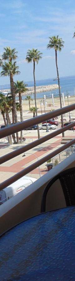 a balcony with a view of the beach and palm trees at Ithaki Phinikoudes Apartment No. 205 in Larnaka