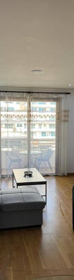 a living room with a couch and a table at Ithaki Phinikoudes Apartment No. 205 in Larnaka