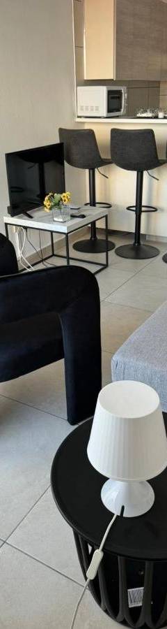 a living room with black chairs and a table at Alex Beach Apartment 203 in Larnaka