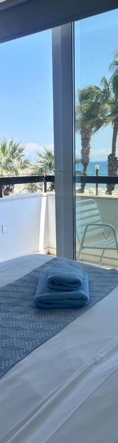 a bedroom with a bed with a view of the beach at Alex Beach Apartment 203 in Larnaka