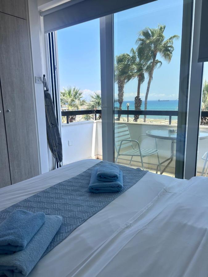 a bedroom with a bed with a view of the beach at Alex Beach Apartment 203 in Larnaka
