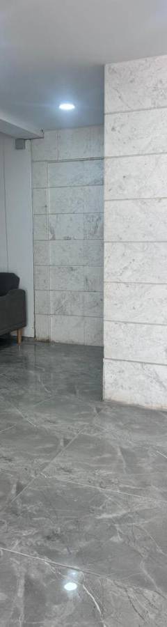 a room with a couch and a stone wall at Alex Beach Apartment 203 in Larnaka
