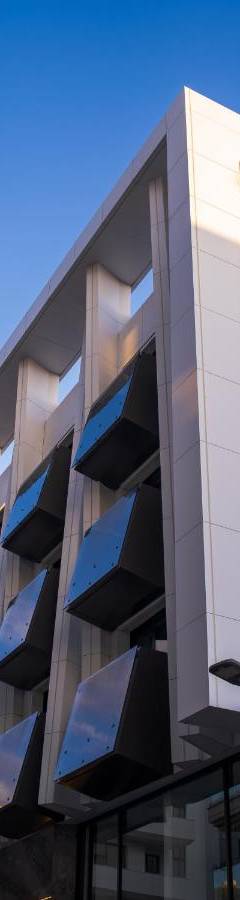a building with blue windows on the side of it at Raam Luxury Suites in Larnaka