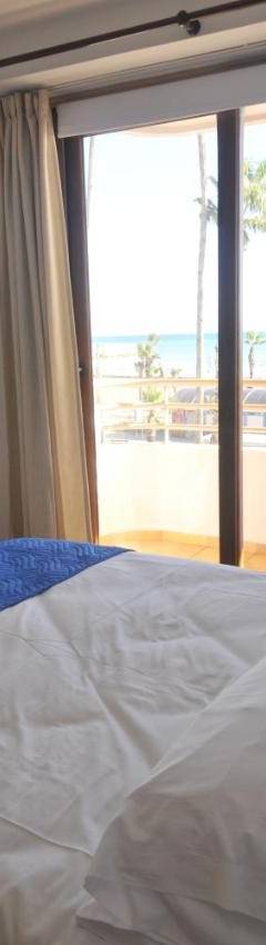 a bedroom with a bed with a view of the beach at Ithaki Phinikoudes Apartment No. 102 in Larnaka