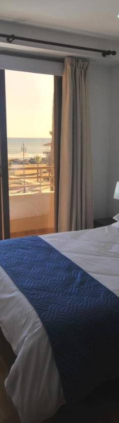 a bedroom with a bed and a window with a view at Ithaki Phinikoudes Apartment No. 102 in Larnaka