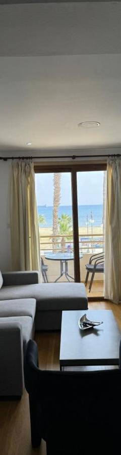 a living room with a couch and a table at Ithaki Phinikoudes Apartment No. 102 in Larnaka