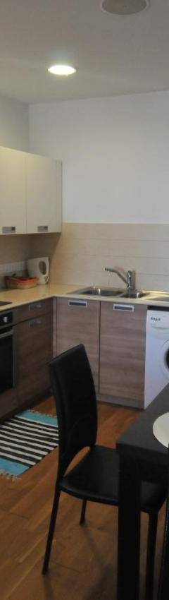 a kitchen with a table and a white refrigerator at Ithaki Phinikoudes Apartment No. 102 in Larnaka