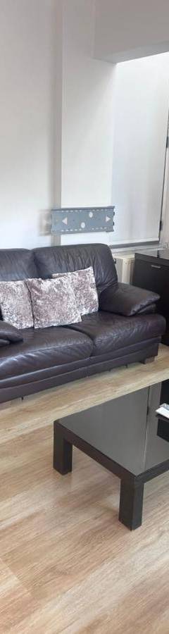 a living room with a black leather couch and a coffee table at Alex Residence in Larnaka