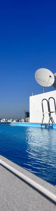 a swimming pool with two chairs in front of a building at Alex Residence in Larnaka