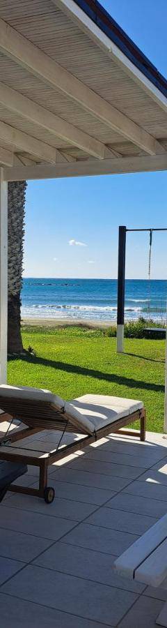 a patio with a hammock and a view of the ocean at Ammos Beachfront Villa Paradise in Larnaca