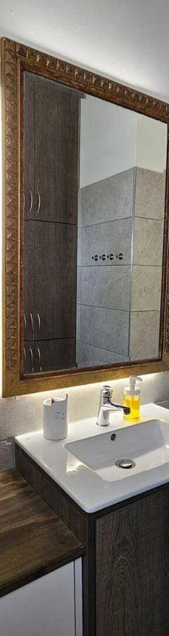 a bathroom with a sink and a mirror at Ammos Beachfront Villa Paradise in Larnaca