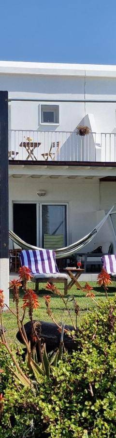 a white house with two chairs in a yard at Ammos Beachfront Villa Paradise in Larnaca