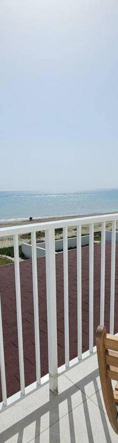 a table and chairs on a balcony with the beach at Ammos Beachfront Villa Paradise in Larnaca