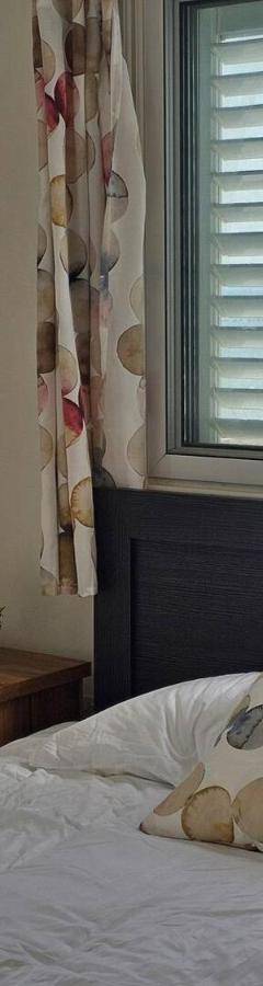 a bed with a pillow in a bedroom with a window at Ammos Beachfront Villa Paradise in Larnaca