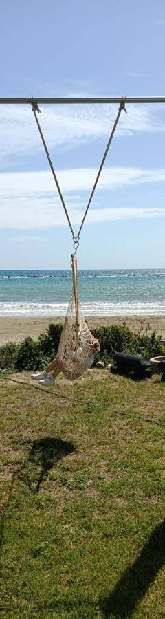 a swing on the beach with the ocean in the background at Ammos Beachfront Villa Paradise in Larnaca