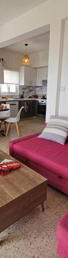 a living room with a purple couch and a table at Ammos Beachfront Villa Paradise in Larnaca