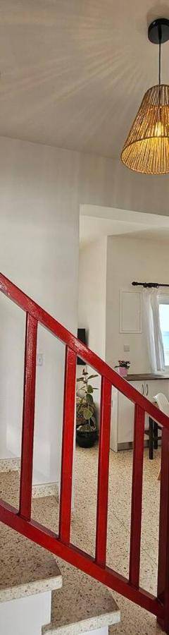 a kitchen with a red door and a kitchen with a table at Ammos Beachfront Villa Paradise in Larnaca