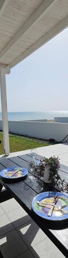 a table with plates of food and a bottle of wine at Ammos Beachfront Villa Paradise in Larnaca