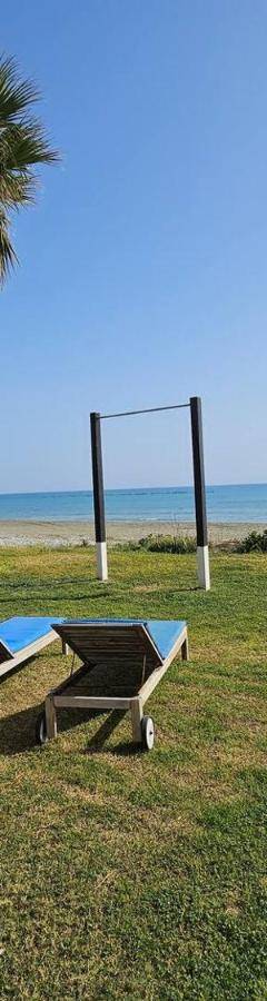 two chairs and a picnic table next to the beach at Ammos Beachfront Villa Paradise in Larnaca