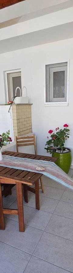 a patio with a table and chairs on a balcony at Ammos Beachfront Villa Paradise in Larnaca