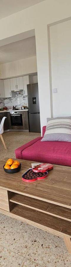 a living room with a pink couch and a table at Ammos Beachfront Villa Paradise in Larnaca