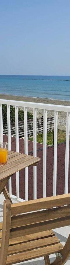 a table and chairs on a balcony with the beach at Ammos Beachfront Villa Paradise in Larnaca