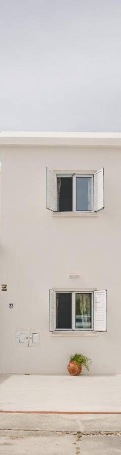 a white building with two windows on the side at Ammos Beachfront Villa Paradise in Larnaca